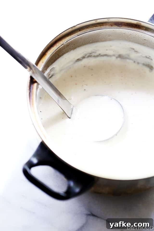 Béchamel sauce is a classic French white sauce made from butter, flour, and milk. Learn how to make béchamel sauce to use in lots of recipes! A ladle resting in a pot of bechamel sauce.