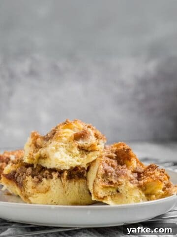 baked challah french toast on a plate with syrup in the background