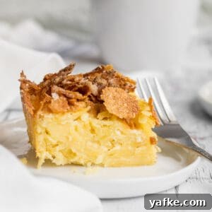 noodle kugel on plate with a fork and mug in background