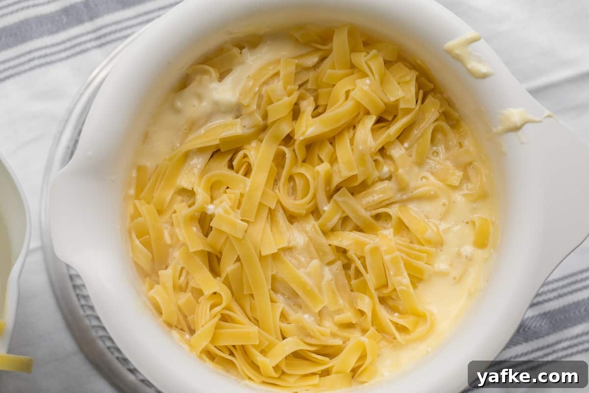 7-Ingredient Sweet Noodle Kugel Recipe 8 noodles added to custard mixture in a mixing bowl.