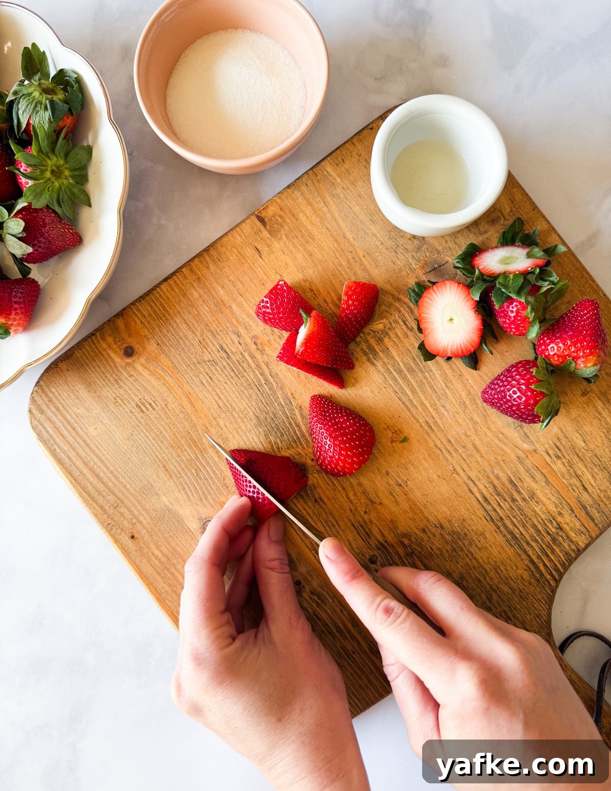 Macerated Strawberries Recipe with Lemon and Vanilla 6 cutting a strawberry into quarters
