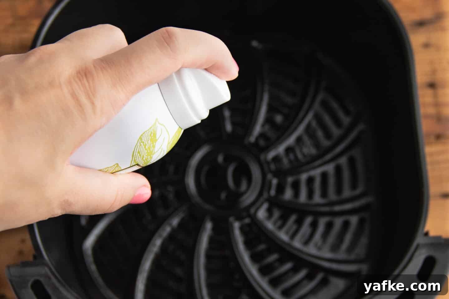 This is a picture of an air fryer and spray cooking oil being sprayed.