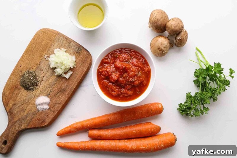 Carrot Spaghetti Recipe: Savory Veggie Noodle Pasta 2 Carrots, marinara sauce, mushrooms, onion, garlic, olive oil, and parsley on a table.