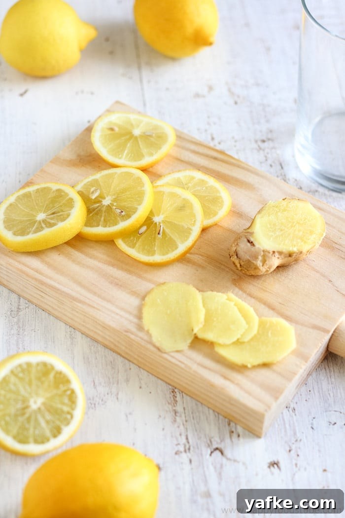How to Make Lemon Ginger Water: Recipe and Benefits 3 Close-up of fresh lemon rounds and sliced ginger on a wooden cutting board.