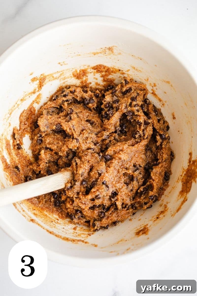 Chewy Almond Butter Chocolate Chip Cookies 5 Cookie dough with chocolate chips in a mixing bowl.