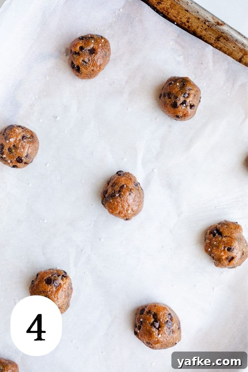 Chewy Almond Butter Chocolate Chip Cookies 6 Cookie dough balls on a baking sheet.