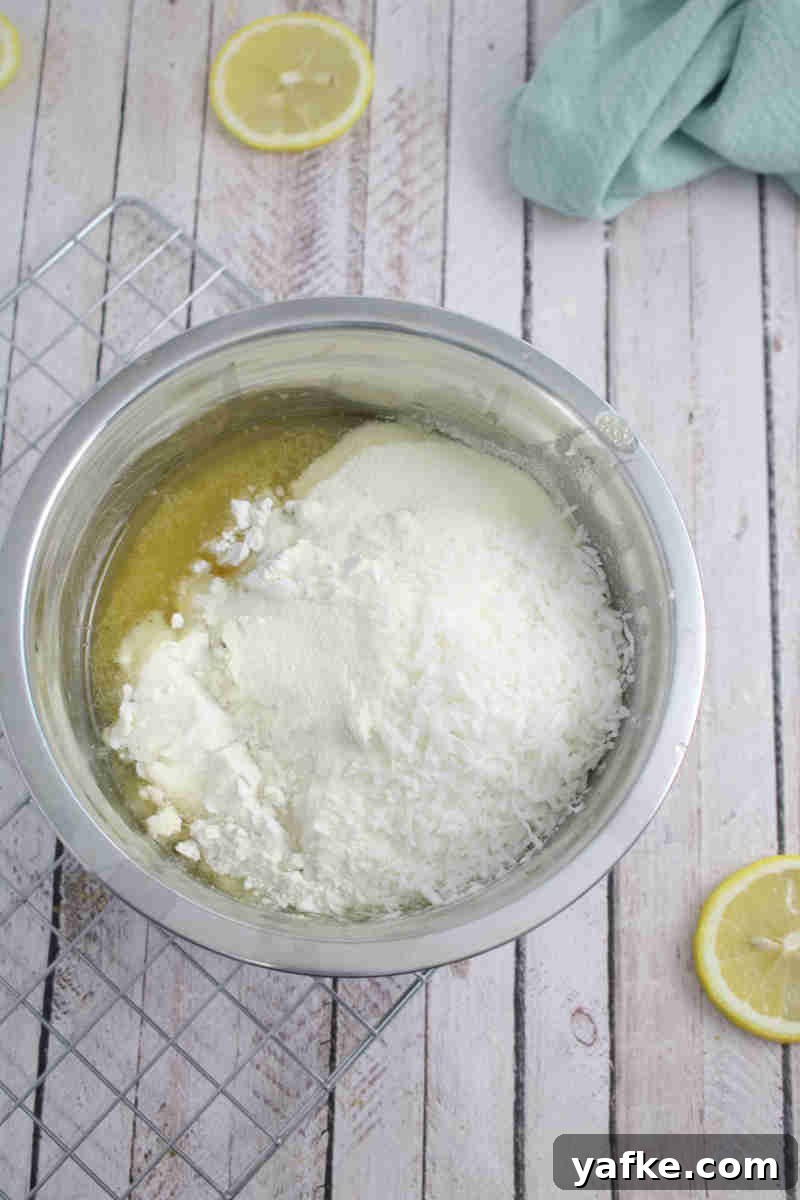Zesty Gluten Free Lemon Protein Muffins Recipe 5 Steel bowl with flour on top of whisked egg.