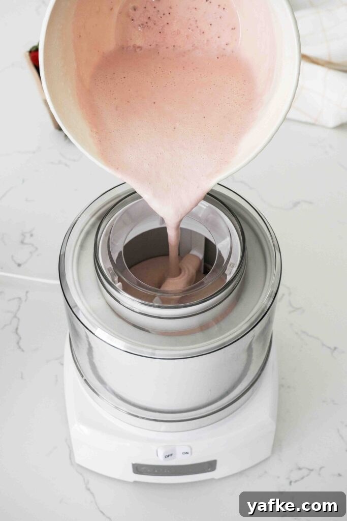 Creamy Homemade Strawberry Ice Cream Recipe 11 Strawberry custard is poured into an ice cream maker.