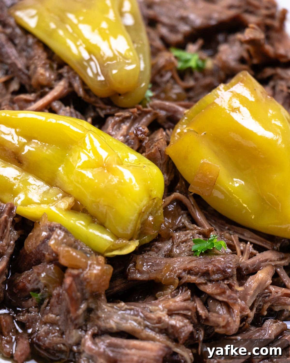 Instant Pot Mississippi Roast with Pepperoncini and Butter 2 close up of instant pot Mississippi pot roast with shredded beef and pepperoncini peppers in gravy.