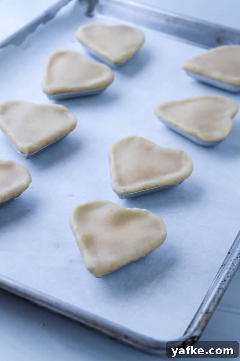 Vaniljhjärtan: Buttery Swedish Custard Heart Cookies 14 Unbaked Swedish Custard Hearts on a rimmed baking sheet.