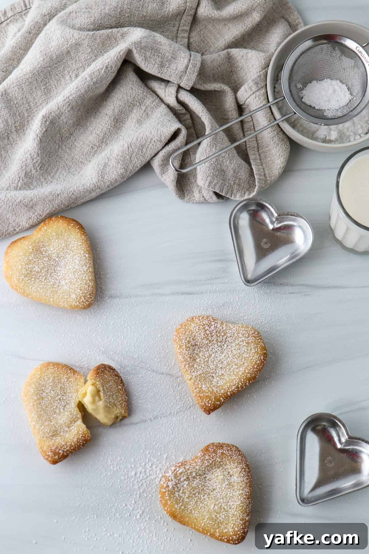 Vaniljhjärtan: Buttery Swedish Custard Heart Cookies 17 Swedish Custard Hearts and molds next to a glass of milk and powdered sugar in a bowl.