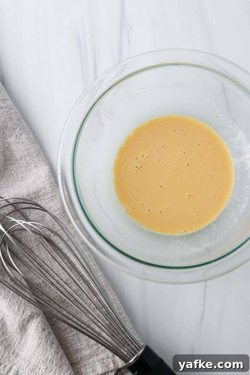 Vaniljhjärtan: Buttery Swedish Custard Heart Cookies 4 Eggs mixed in a bowl next to a whisk.