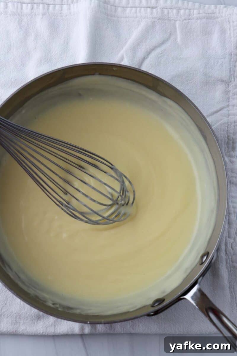 Vaniljhjärtan: Buttery Swedish Custard Heart Cookies 9 Saucepan with pastry cream and a whisk inside.