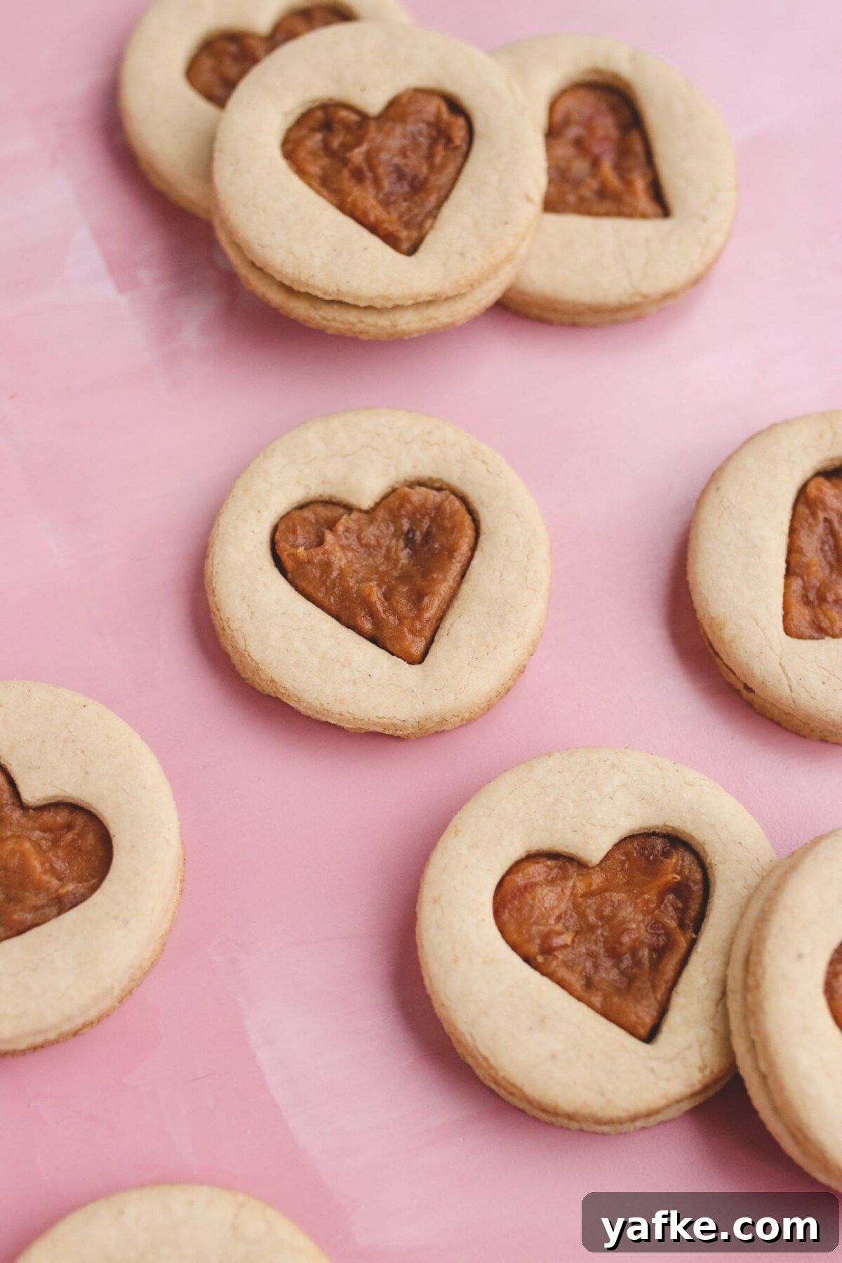 Vegan Gluten-Free Salted Caramel Cookies Recipe 4 heart shaped sandwich cookies on a pink background