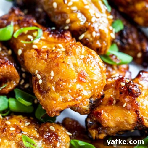 Close up shot of several chicken wings with sesame seeds.