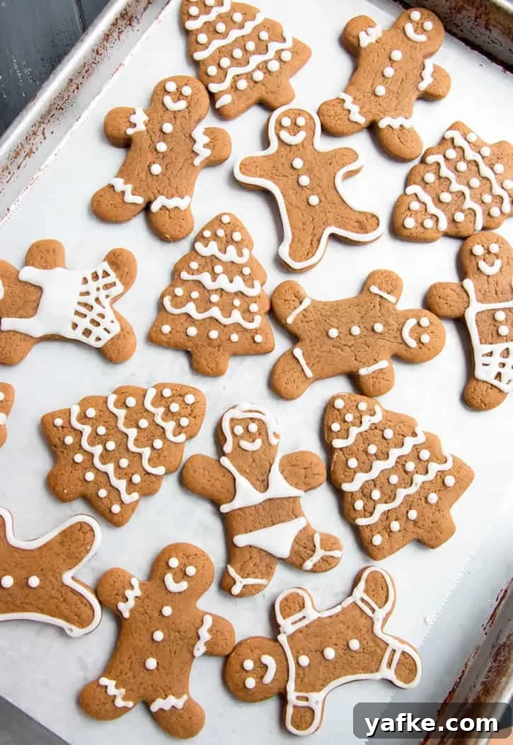 Soft Gingerbread Cookies with Molasses and Warm Spices 2 Soft Gingerbread Men, trees and women Cookies with icing trimming on a baking tray by themerchantbaker.com
