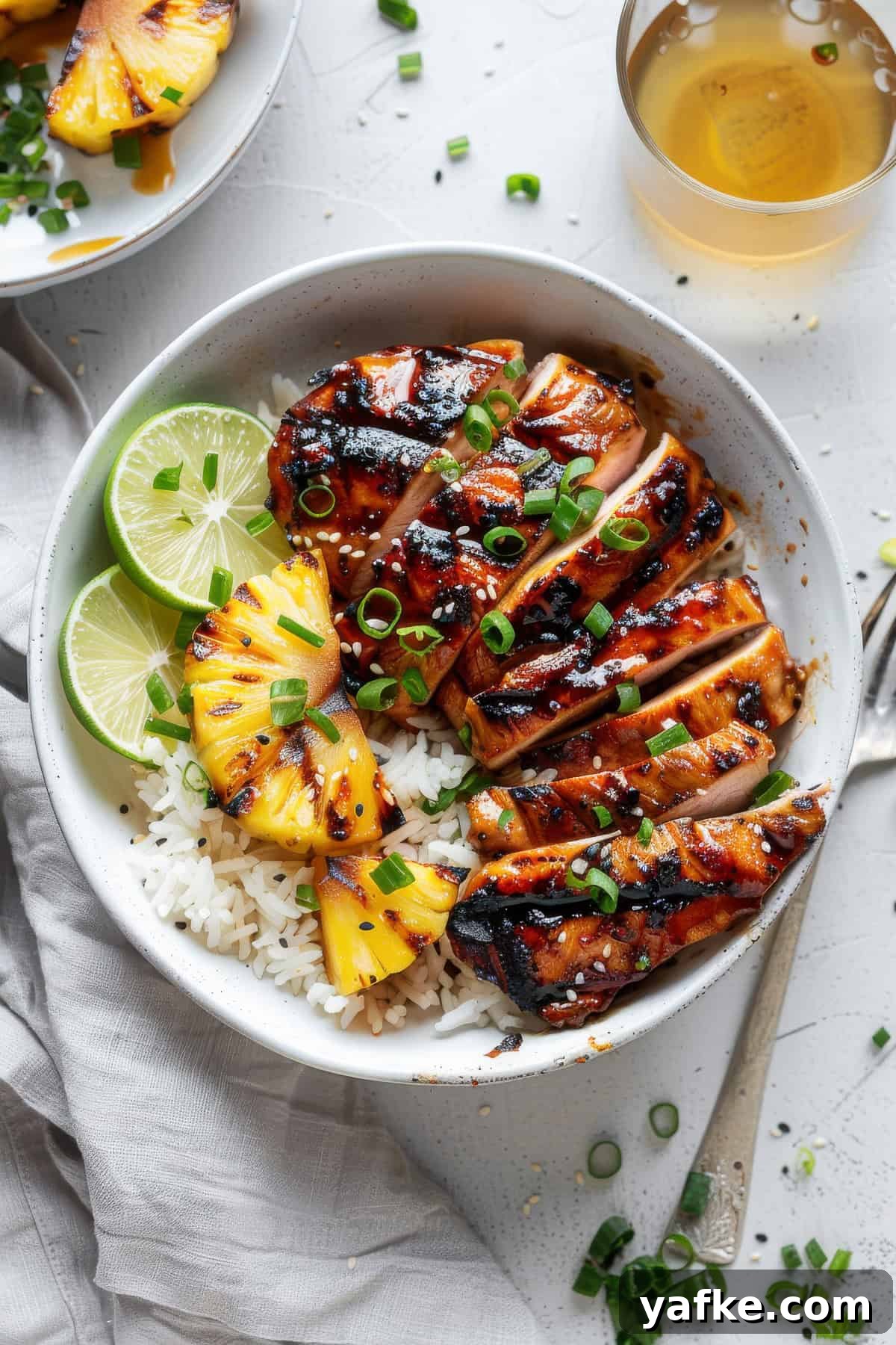 Soy-Ginger Marinated Asian Grilled Chicken Recipe 2 Grilled Asian chicken over rice in a bowl with limes.