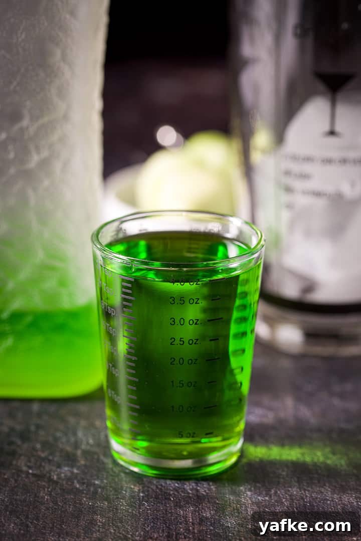 Melon Ball Cocktail Recipe: How to Make the Classic Drink 5 Melon liqueur measured out with the bottle and ice filled shaker in the background
