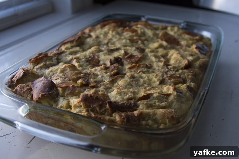 Salted Caramel Pretzel Banana Bread Pudding Recipe 9 Finished pretzel bread pudding in a glass baking dish cooling on a white table top near a window.