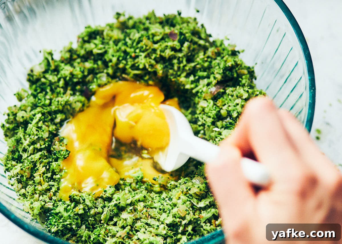 Crispy Air Fryer Broccoli Tater Tots 7 Stirring eggs into broccoli tots mixture in a glass bowl.