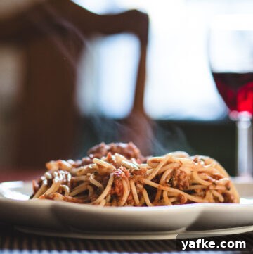 Steamy plate of pasta bolognese.