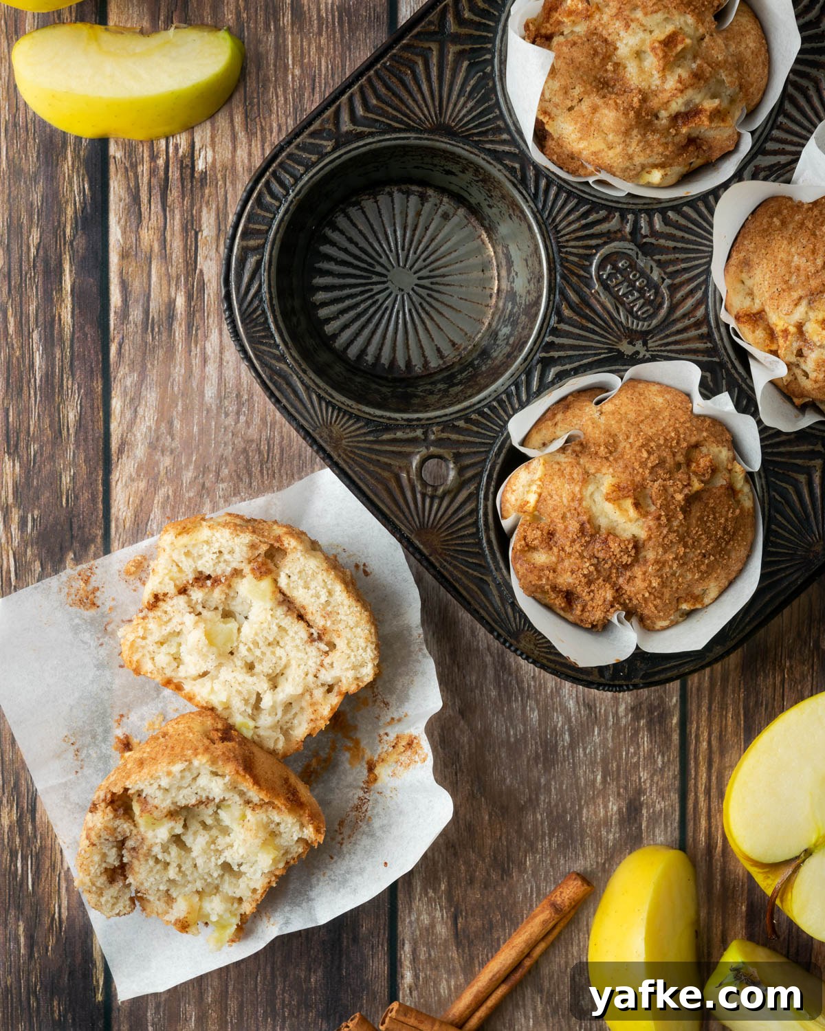 Gluten-Free Apple Cinnamon Muffins 13 Cut open gluten free apple muffin on a wood table.