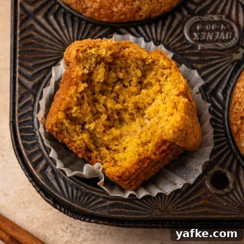 Gluten-Free Apple Cinnamon Muffins 17 A pumpkin banana muffin with a bite taken out.