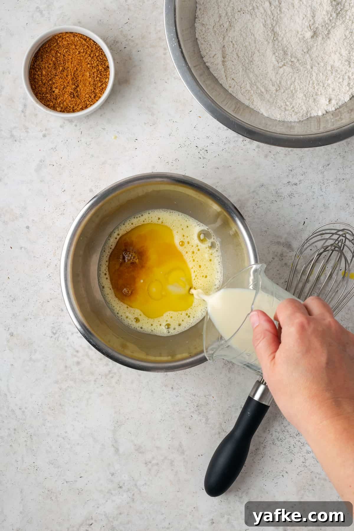 Gluten-Free Apple Cinnamon Muffins 7 Beaten egg, oil, vanilla and milk being mixed in a small metal bowl.