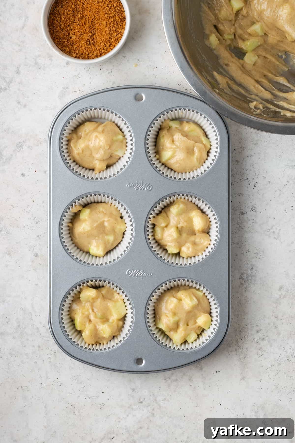 Gluten-Free Apple Cinnamon Muffins 10 Gluten free apple muffin batter in a 6 cup muffin pan.