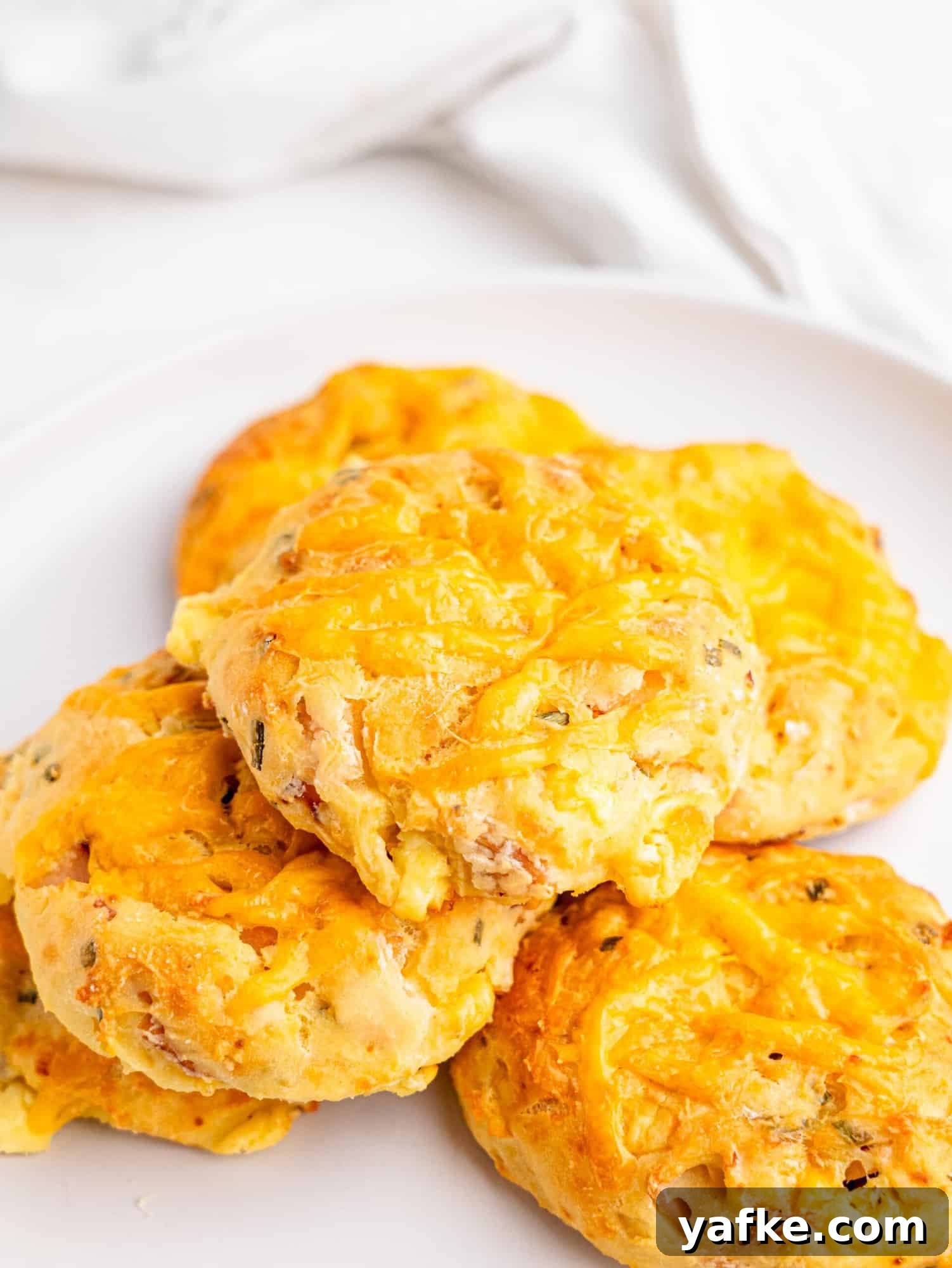 High-Protein Butter-Free Biscuits Recipe 2 Protein biscuits with ham and cheese on a white plate.