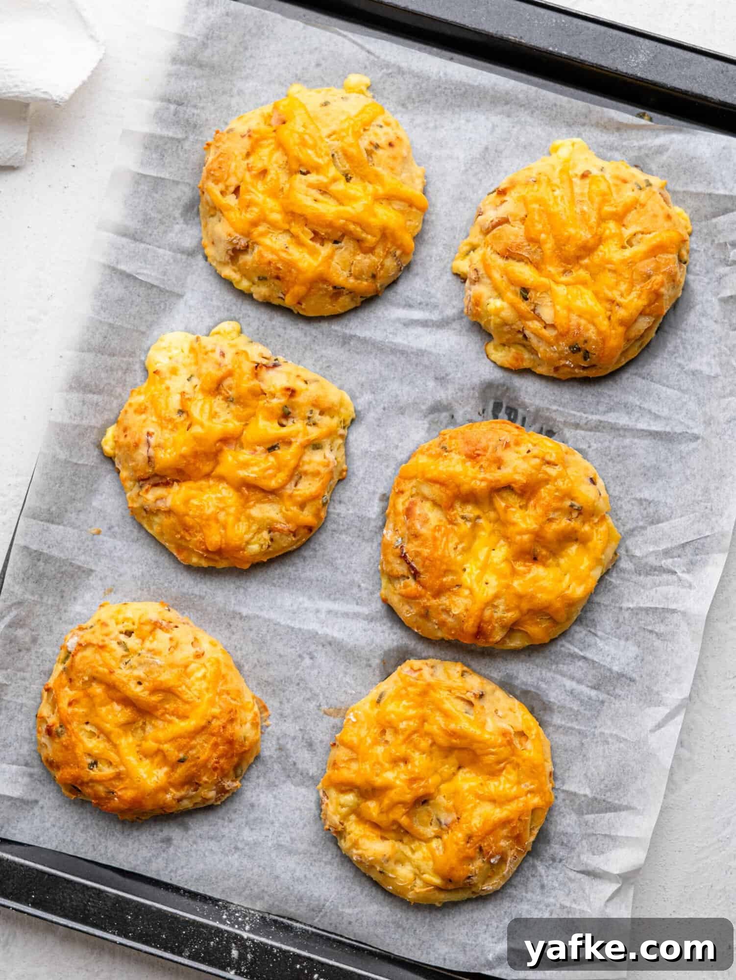 High-Protein Butter-Free Biscuits Recipe 11 Freshly baked breakfast biscuits on a baking tray.