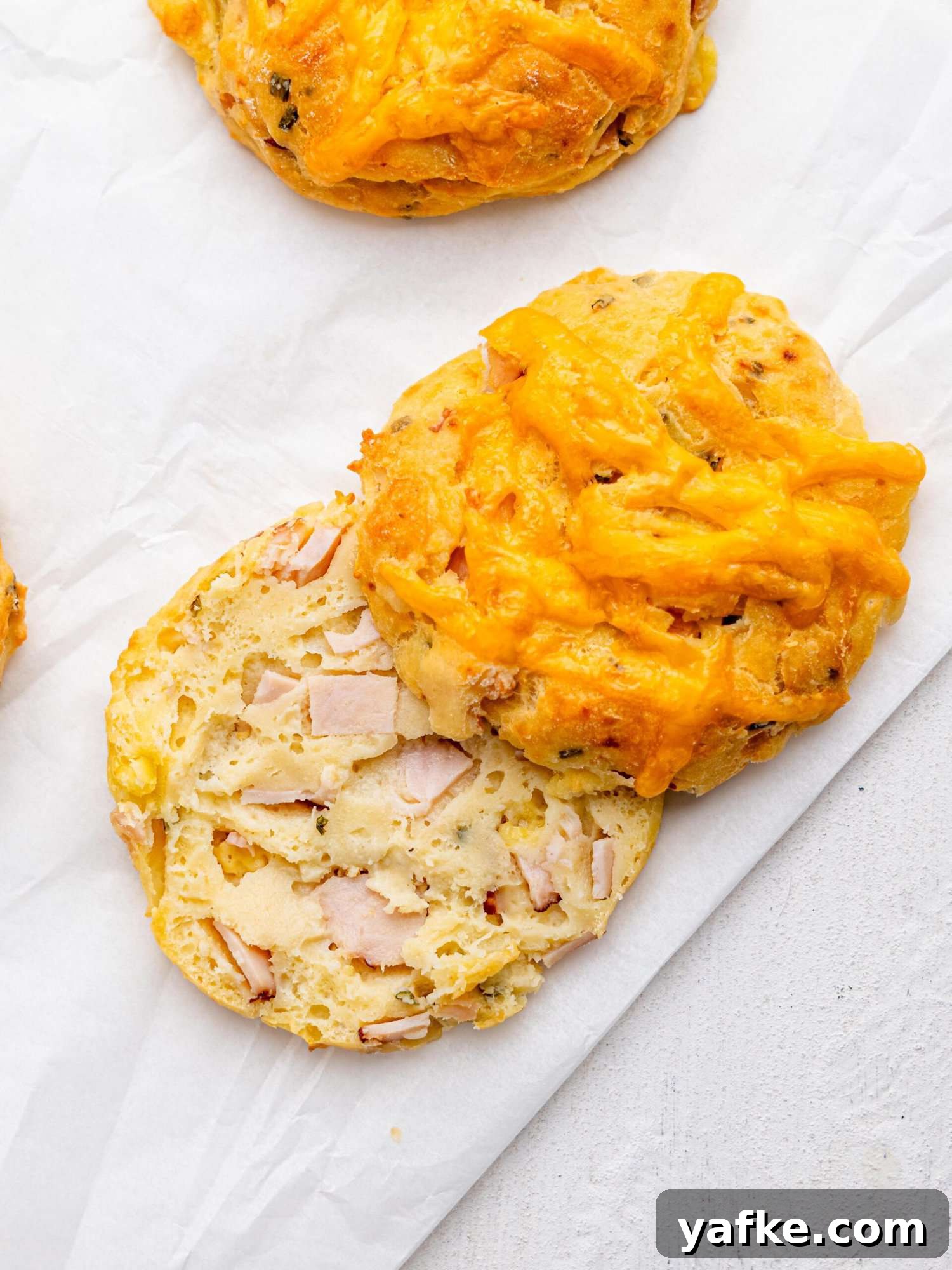 High-Protein Butter-Free Biscuits Recipe 3 Bird's eye view of a ham and cheese biscuit cut in half.