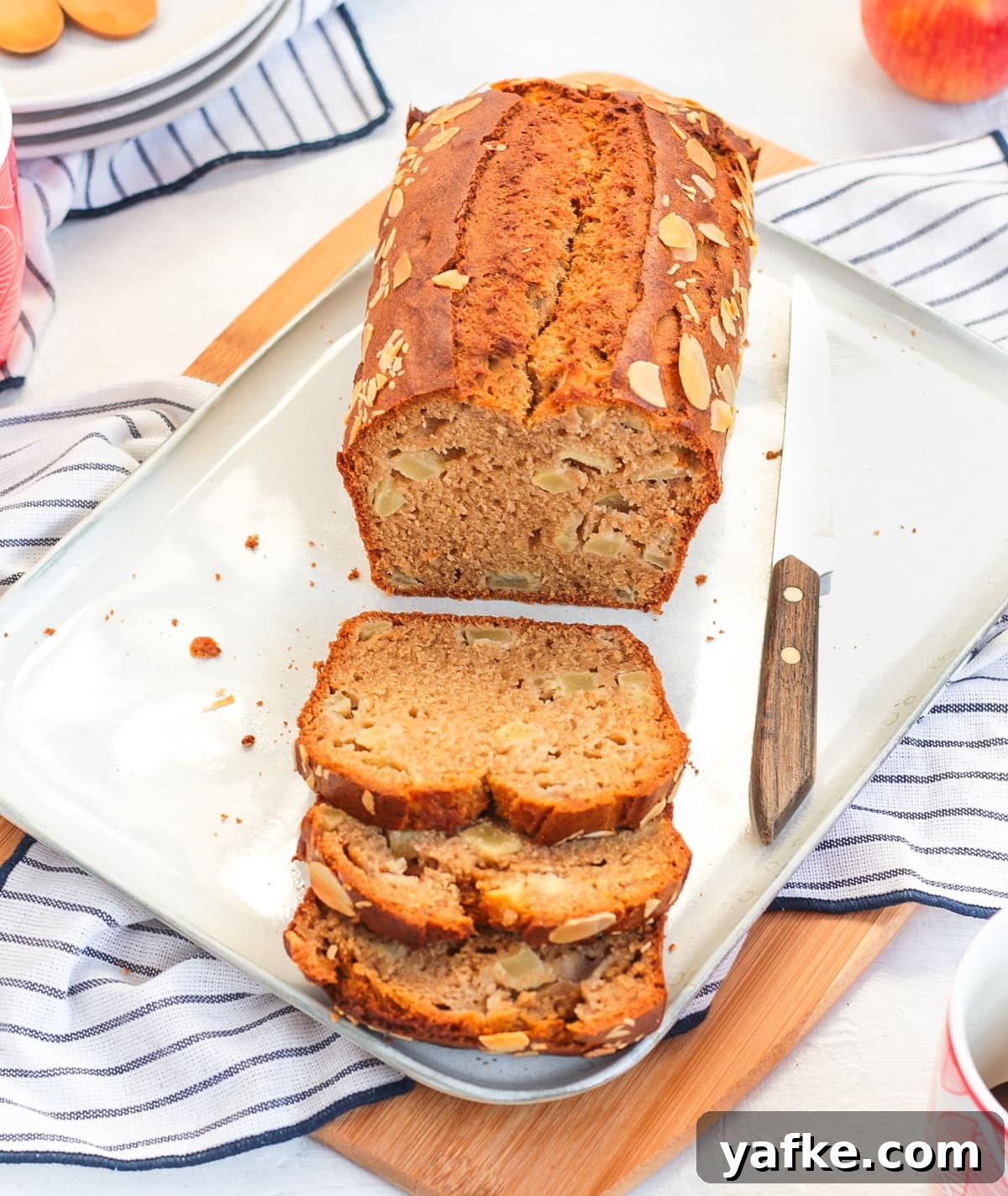 Moist Apple Loaf Cake with Cinnamon Glaze 4 Loaf on a white rectangular plate half sliced off.