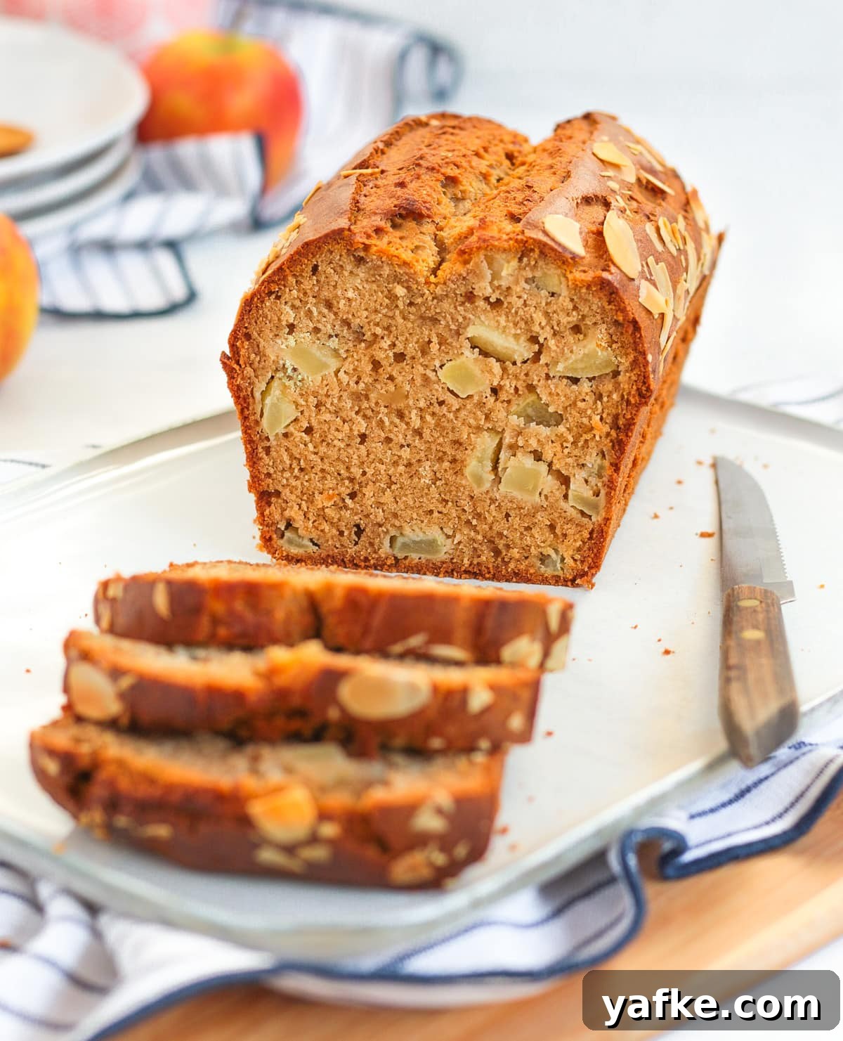 Moist Apple Loaf Cake with Cinnamon Glaze 5 Cake on a white plate with 3 pieces sliced off