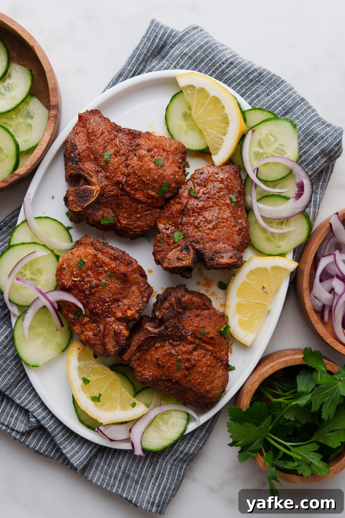 Air Fryer Lamb Chops Recipe with Garlic and Herbs 2 A delicious plate with tender lamb chops, cucumber slices, and zesty lemon wedges.