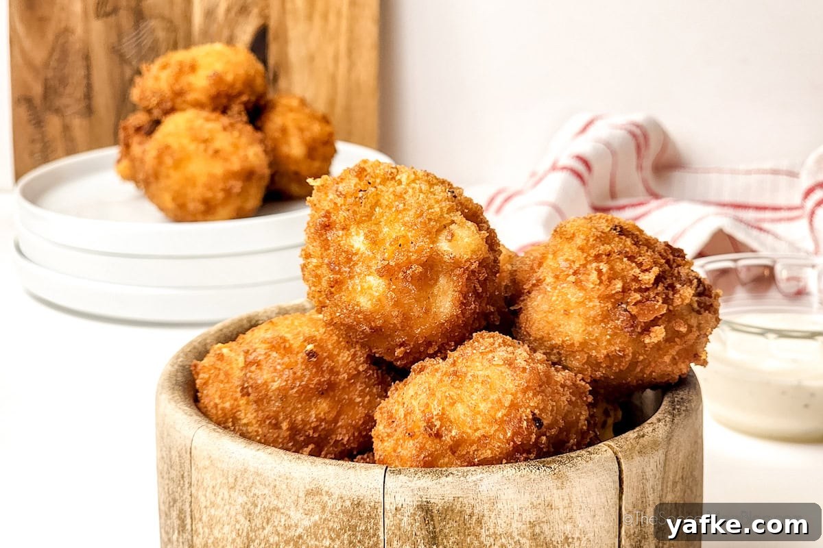 Crispy Fried Mac and Cheese Balls Recipe with Gooey Center 5 fried mac and cheese bites in a bowl.