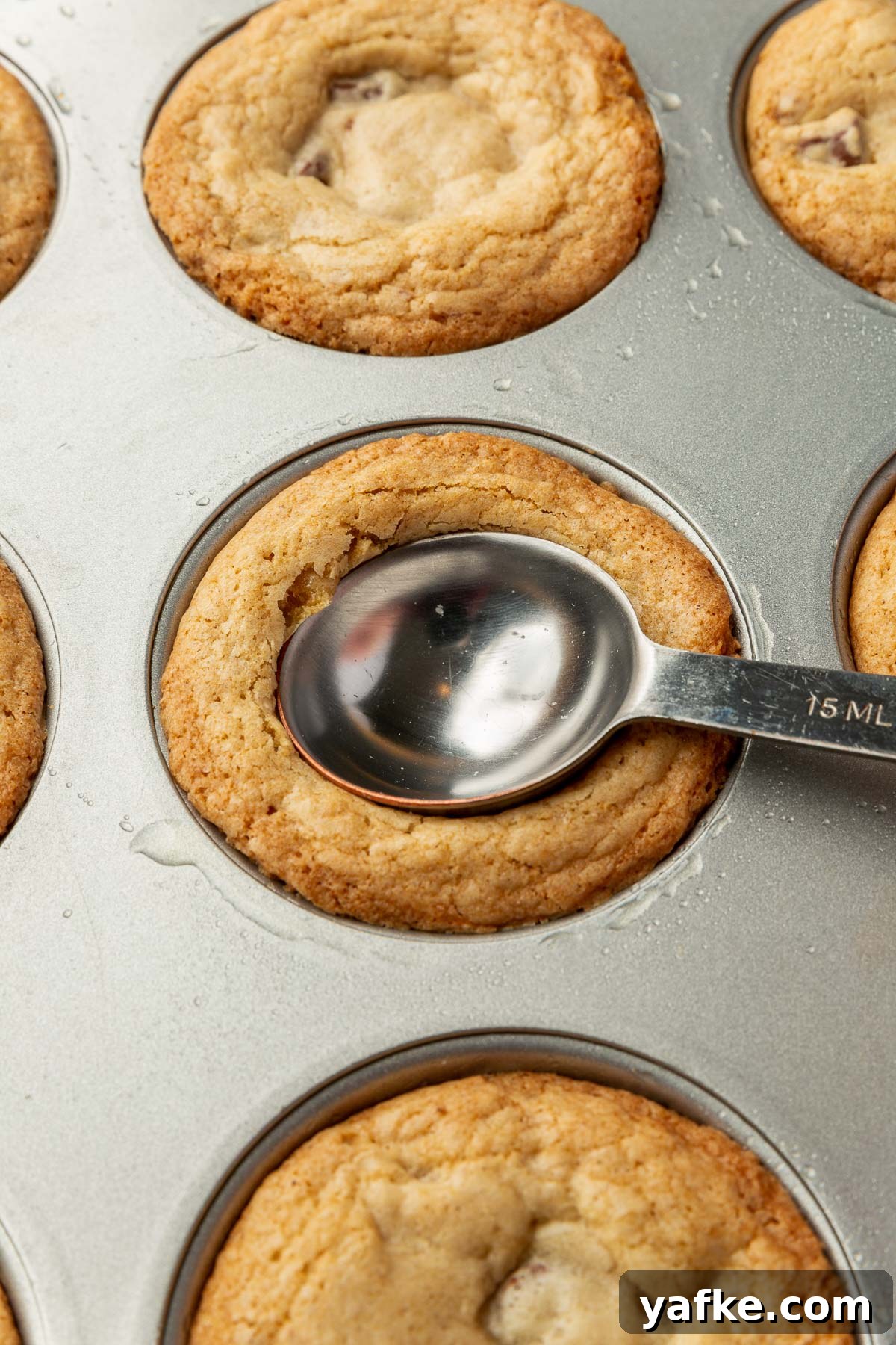 Gluten-Free Chocolate Chip Cookie Cups Recipe 10 Pressing an indentation into a warm cookie cup with a spoon.