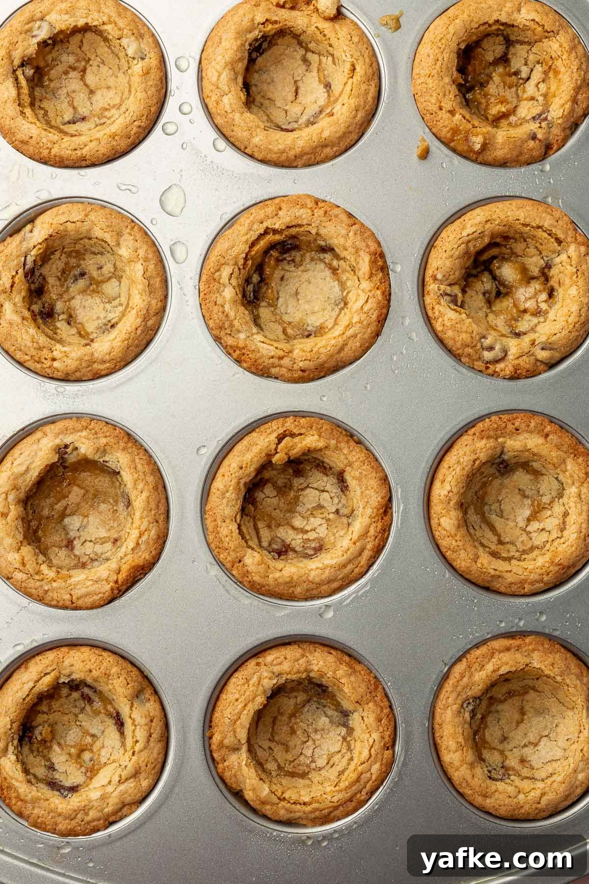 Gluten-Free Chocolate Chip Cookie Cups Recipe 11 Cookie cups cooling in a muffin tin before decorating.