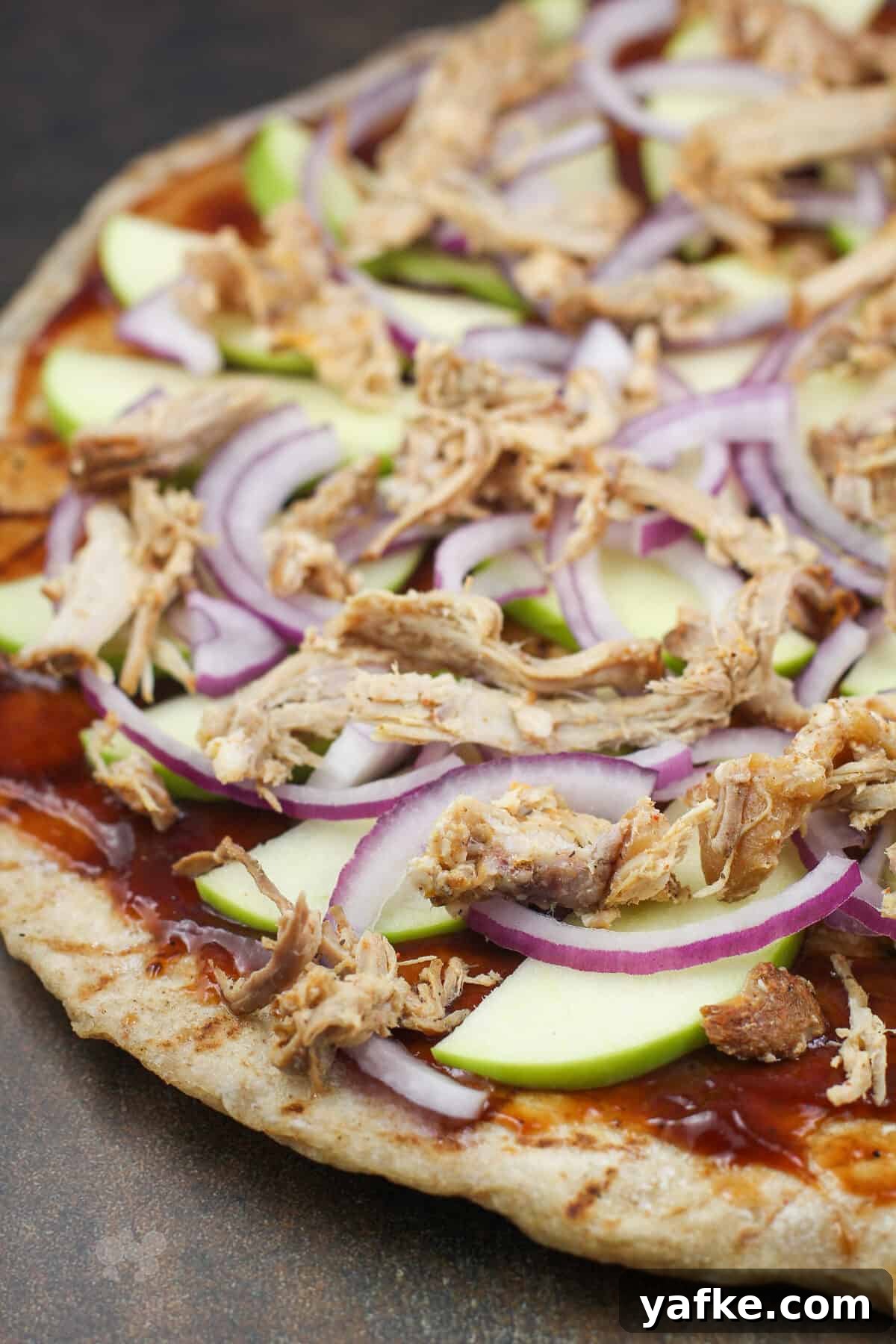 Caramelized Apple and Pulled Pork Pizza 2 pizza toppings on crust before adding cheese.