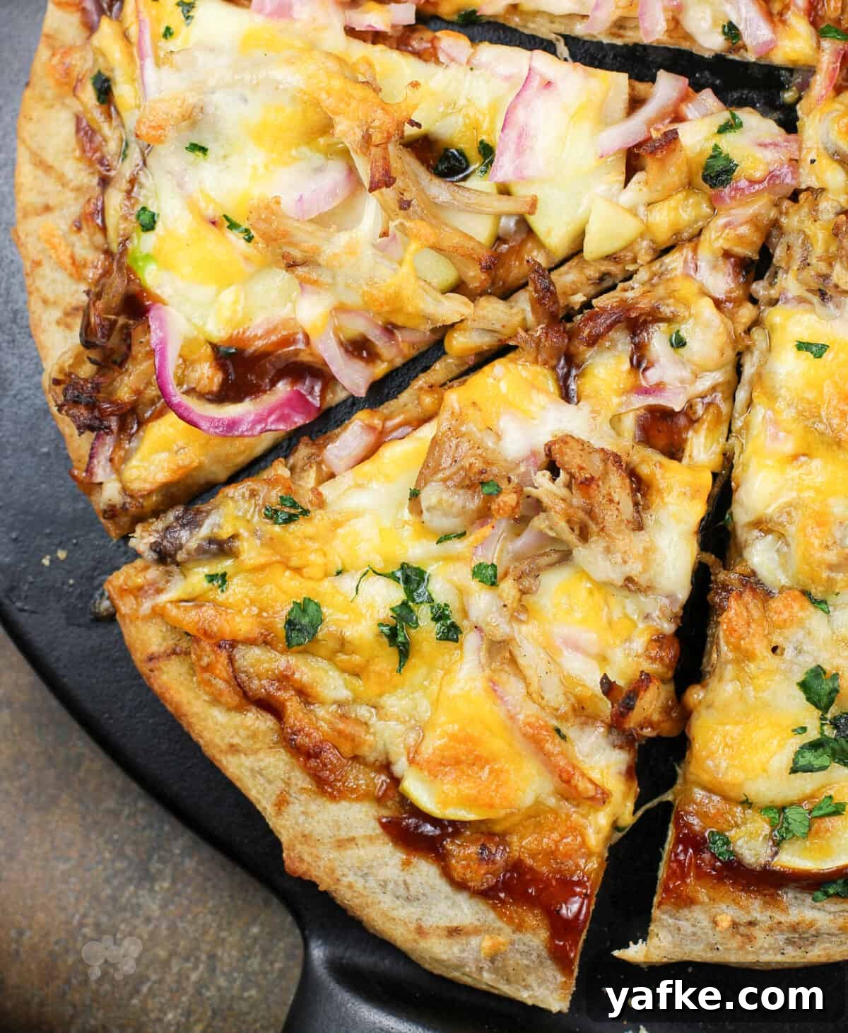 Caramelized Apple and Pulled Pork Pizza 3 slice of pizza on black pizza stone.