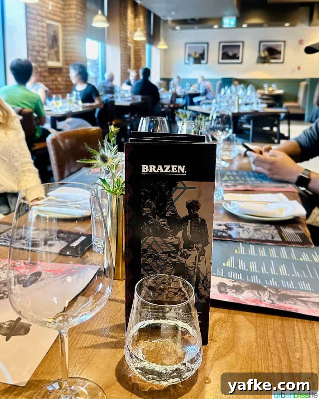 Bold Banff Adventures: What to Do in Banff National Park 3 table and interior photo of Brazen Banff restaurant with menu in foreground.