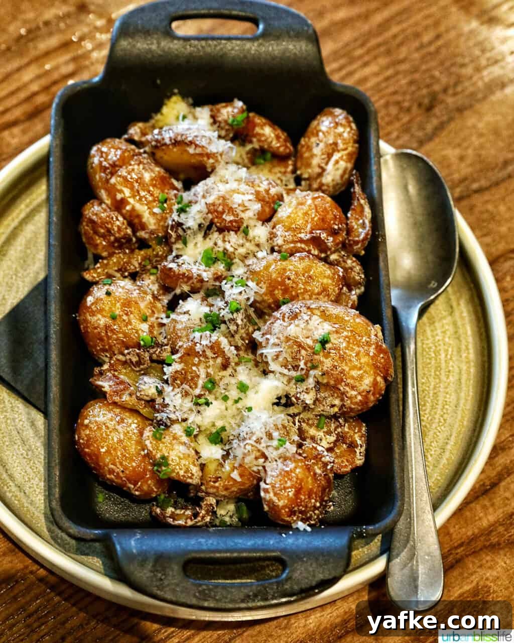 Bold Banff Adventures: What to Do in Banff National Park 6 parmesan truffle potatoes in a cast iron serving plate with spoon.