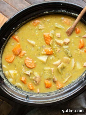 Hearty Slow Cooker Split Pea Stew Recipe 6 split pea stew in a slow cooker with wooden ladle in it.