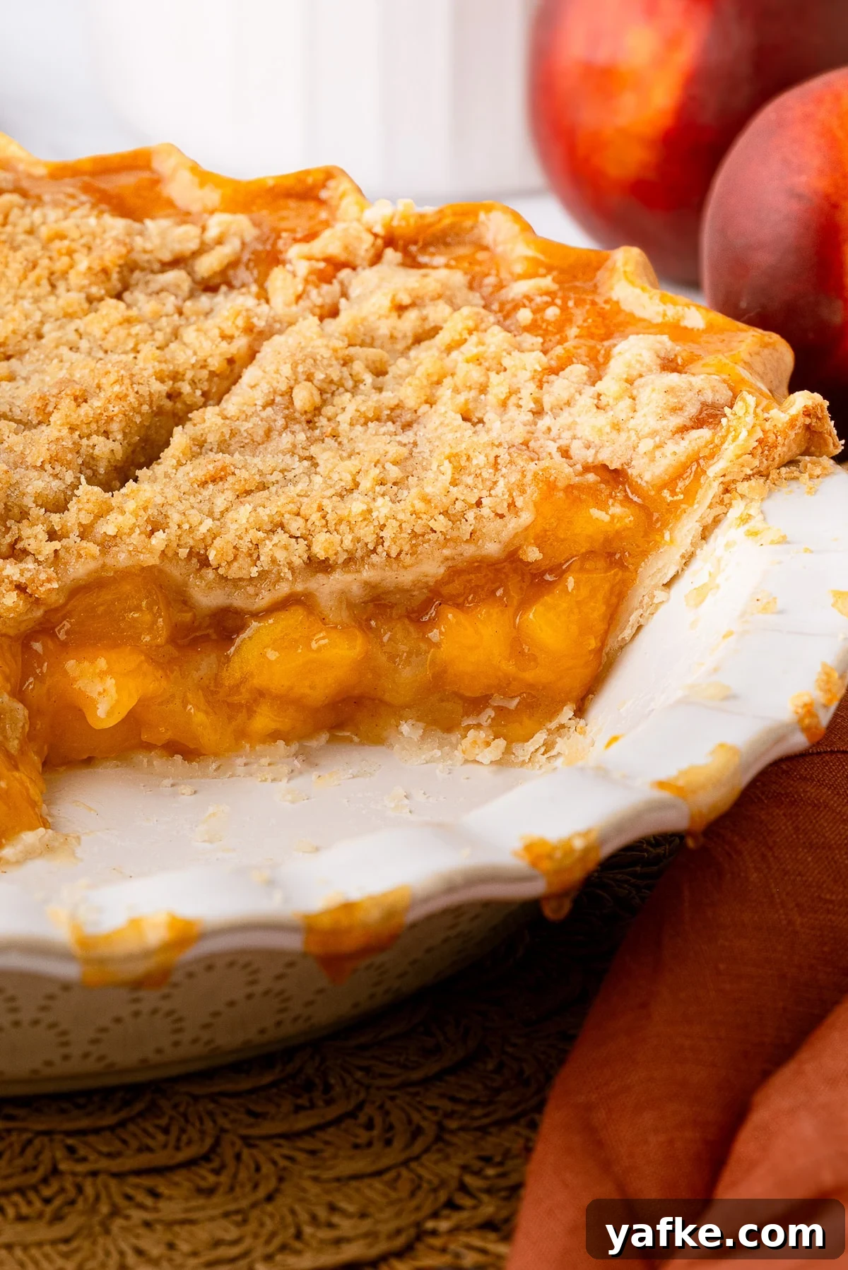 Classic Peach Crumble Pie with Brown Sugar Streusel 2 A golden-brown Texas peach crumble pie with a crisp, buttery streusel topping, served in a deep-dish pie plate.