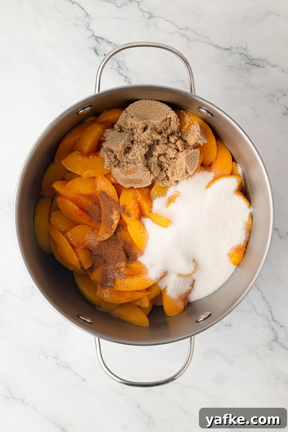 Classic Peach Crumble Pie with Brown Sugar Streusel 5 Sliced peaches cooking with sugar and cinnamon in a large pot on the stovetop to make a thick pie filling.