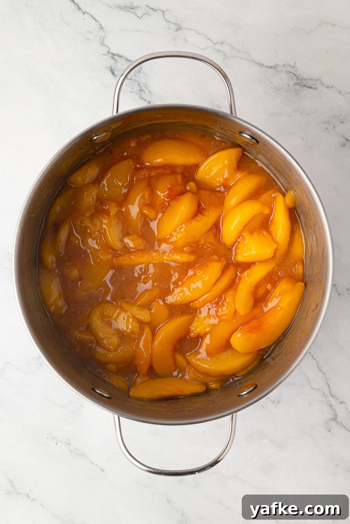Classic Peach Crumble Pie with Brown Sugar Streusel 7 A close-up of thick, velvety precooked peach pie filling coated in a glossy syrup.