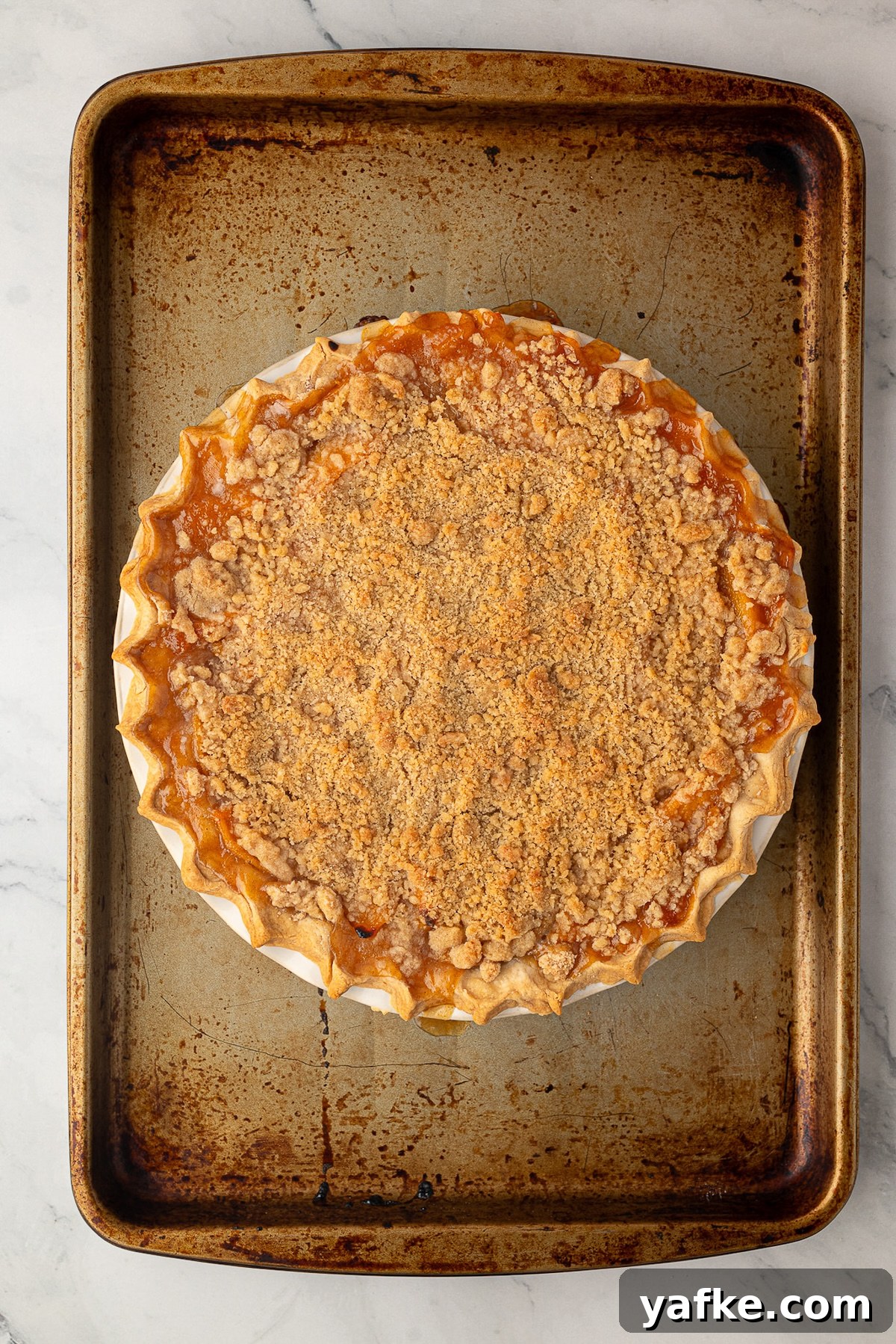Classic Peach Crumble Pie with Brown Sugar Streusel 10 Peach pie placed on top of a baking sheet to catch any bubbling fruit juices.