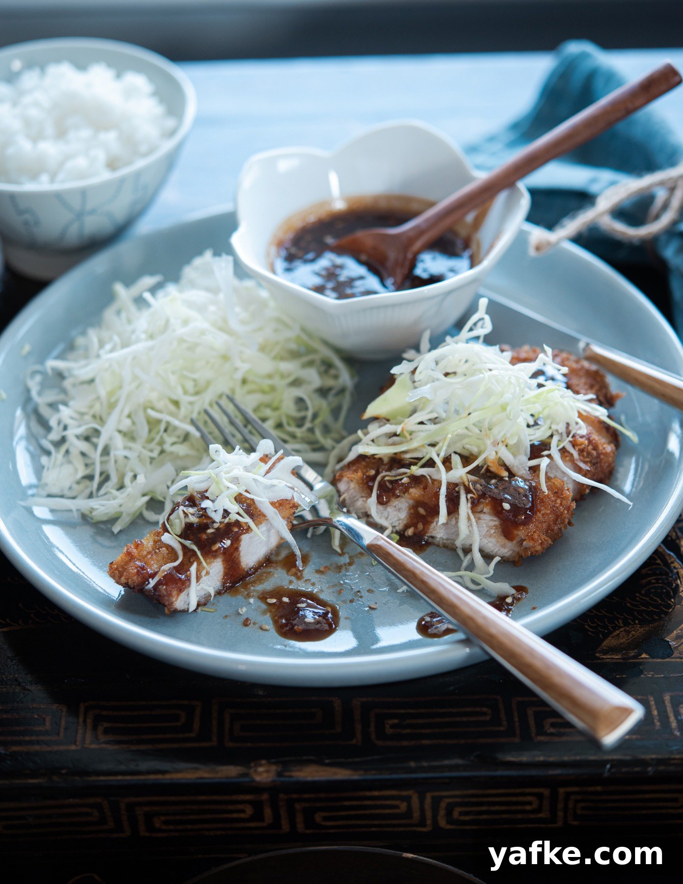 How to Make Crispy Japanese Tonkatsu in 30 Minutes 14 Sliced tonkatsu drizzled with sauce and served with shredded cabbage