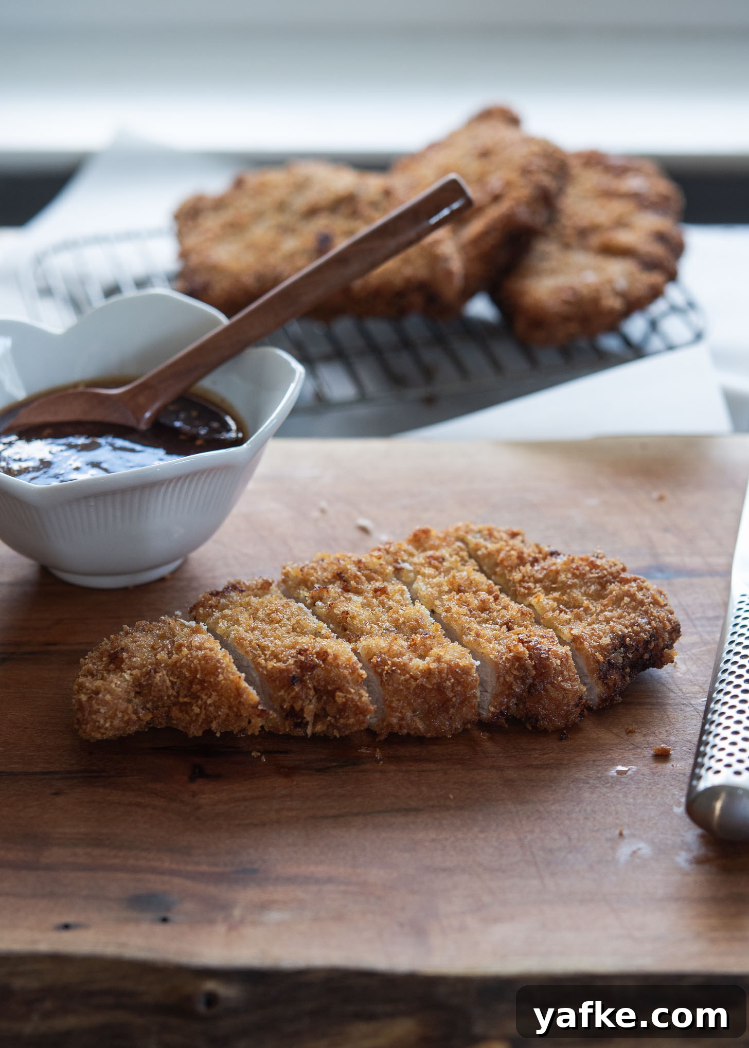 How to Make Crispy Japanese Tonkatsu in 30 Minutes 2 Crispy breaded pork cutlet on a board with dipping sauce