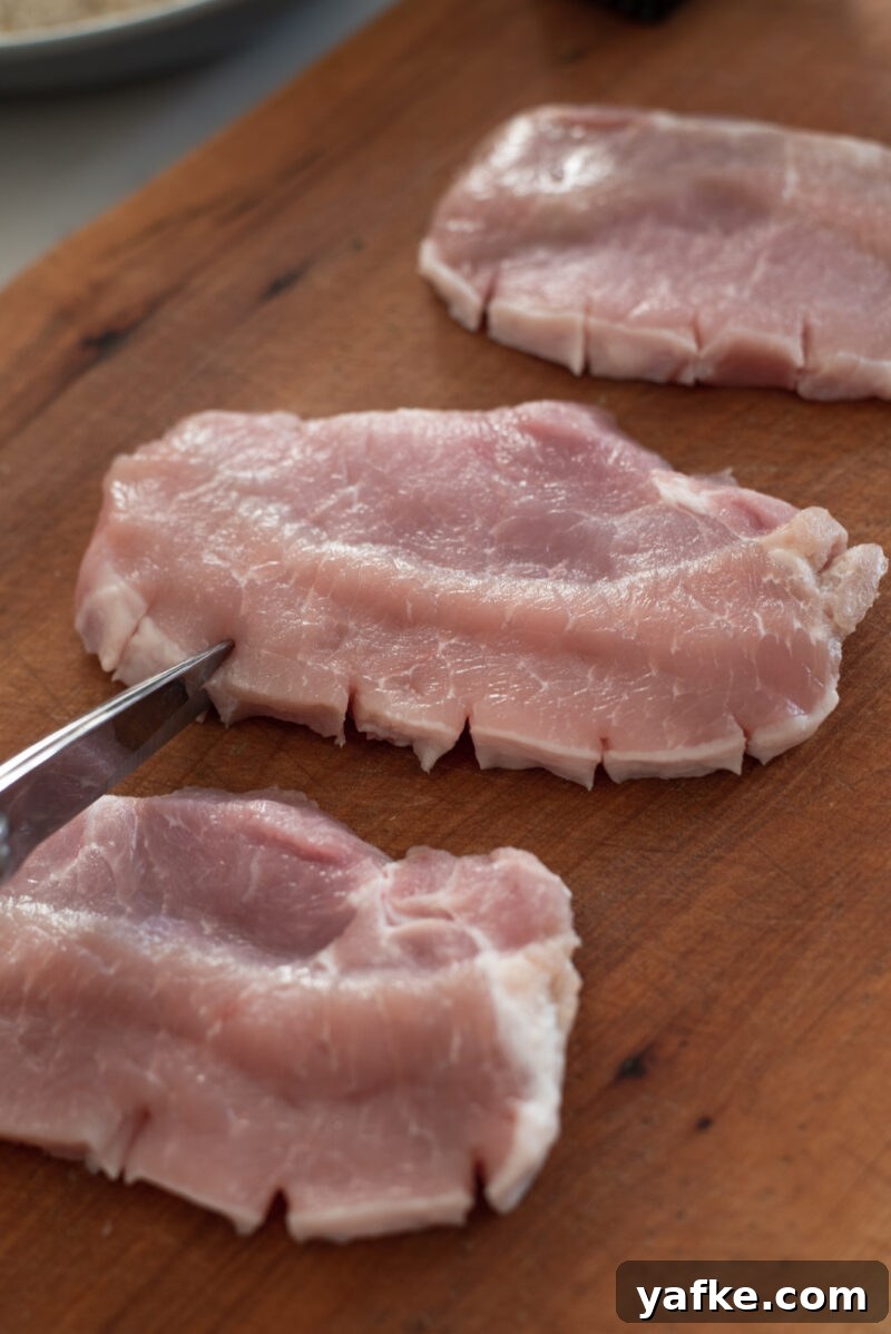 How to Make Crispy Japanese Tonkatsu in 30 Minutes 6 Snipping fat edges of pork loin to prevent curling